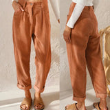 
A woman standing wearing high-waisted terracotta corduroy cropped pants, showing the lower half of her body with emphasis on the pants.
