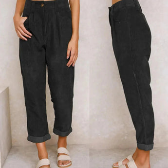 
A woman is modeling high-waisted terracotta corduroy cropped pants. The pants are styled with a high waist and a cropped length, showcasing a trendy and fashionable appearance. The model is standing with a white and black outfit, emphasizing the pants' textured and stylish look.