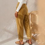 Women's high-waisted terracotta corduroy cropped pants displayed on a model, showcasing the waist, knee, and thigh areas with a casual fashion design. The model is wearing a beige blazer to complement the pants, highlighting a stylish outfit choice.