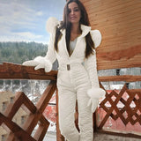 Women's black hooded winter jumpsuit with stylish ski fashion, featuring a fitted waist, full-length sleeves, and a high collar, suitable for cold weather activities. The model is smiling while wearing the jumpsuit.