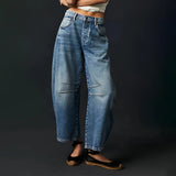 
A model wearing dark blue high-waisted cargo pants featuring a relaxed fit, paired with a stylish blazer, showcasing a blend of sustainable streetwear fashion.