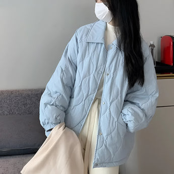Women's light blue oversized quilted puffer jacket, featuring a stylish design with long sleeves, a collar, and a comfortable fit that extends to the thigh.