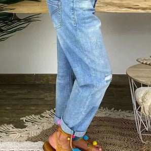 Women's light-wash high-waist ankle-length relaxed fit jeans, featuring denim fabric in a light blue color.