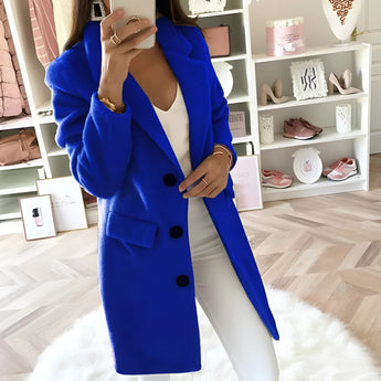 Women's long blue double-breasted blazer in a tailored office chic style, featuring structured shoulders, a defined waist, and long sleeves.
