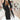 
A woman wearing a women's long black double-breasted blazer, tailored for an office chic look, in size 4XL. The blazer features classic fashion design elements like a structured collar, long sleeves, and a defined waist, giving it a sophisticated and polished appearance.