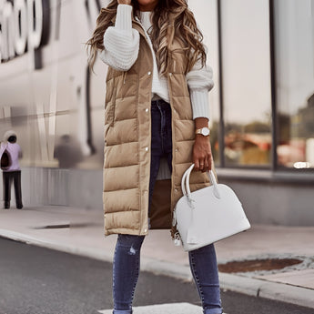 Long beige puffer vest for women in 5XL, styled as urban chic winter jacket with knee-length design, featuring a sleeveless cut and tailored waist, shown with fashionable accessories.