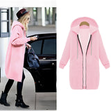 Women's long blue oversized zip-up hoodie displayed against an urban streetwear backdrop, highlighting its fashion-forward design and cozy outerwear features.