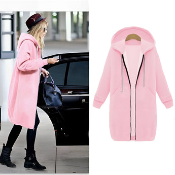 Women's long blue oversized zip-up hoodie displayed against an urban streetwear backdrop, highlighting its fashion-forward design and cozy outerwear features.