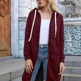 
A woman wearing a long blue oversized zip-up hoodie styled in urban streetwear fashion, with a focus on the shoulder and sleeve details. She is also wearing sunglasses and jeans, creating a casual and trendy look.