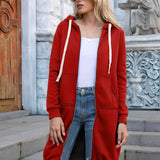 A woman wearing a long blue oversized zip-up hoodie styled as urban streetwear, paired with sunglasses, showcasing a casual and trendy fashion look.