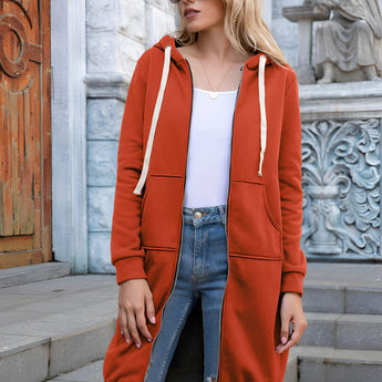 Women's long blue oversized zip-up hoodie styled in urban streetwear fashion, worn by a woman accessorized with sunglasses.