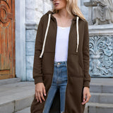 
A woman wearing an oversized long blue zip-up hoodie in urban streetwear style, paired with jeans. She is standing outdoors, with sunglasses on, showcasing a fashionable look.