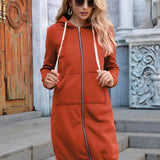Women's long blue oversized zip-up hoodie styled with urban streetwear featuring sunglasses and orange accents against a white background.