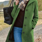 
A stylish woman's long green wool coat in a button-down tweed design, perfect for fall fashion. The coat is modeled in size 2XL and features a classic overcoat style with tartan pattern accents, complemented by sleek sleeves. The wearer stands confidently, accessorized with sunglasses.