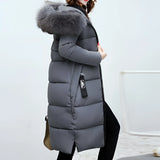 
A gray women's long puffer jacket with a fur hood, designed for winter insulation, shown in size 3XL. The coat features long sleeves and covers the waist, providing warmth and comfort.