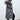 
A gray women's long puffer jacket with a fur hood, designed for winter insulation, shown in size 3XL. The coat features long sleeves and covers the waist, providing warmth and comfort.