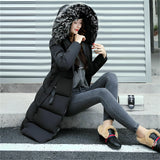 Women's black long puffer jacket with a fur hood, designed as an insulated winter coat in size 3XL, worn by a model.