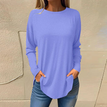 
A woman's long-sleeve tunic in a vibrant blue shade, styled as a casual lightweight sweater. The tunic is worn by a person with visible arms, who pairs it with jeans, showcasing a relaxed and comfortable fit suitable for everyday wear.
