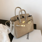 Luxurious women's designer tote handbag crafted from white crocodile leather with a light khaki hue. The bag features a rectangular shape, suitable for shoulder carrying, exuding elegance and fashion-forward design.