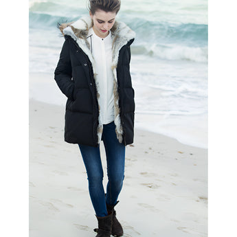 Women's luxury white puffer jacket with a fur hood, featuring a sleek design and comfortable fit, worn by a smiling woman outdoors.