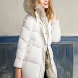 Women's luxury white puffer jacket with a fur hood, showcasing a stylish fashion design, long sleeves, and a defined waist. The coat is made with natural materials, emphasizing the plush fur trim around the collar.