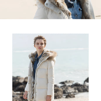 Women's luxury white puffer jacket with fur hood displayed on a mannequin, showcasing its elegant outerwear design, soft textile material, and full-length sleeves against a plain background.