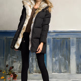 Women's luxury white puffer jacket with a fur hood, showcasing a winter coat design. The jacket features a stylish and warm textile material, with details on the shoulder, sleeve, and waist areas, emphasizing a tailored fit.