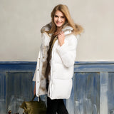 White puffer jacket with fur hood worn by a woman standing and smiling, showcasing the coat's luxurious design and winter style.