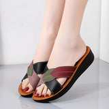 Women's multicolor leather wedge heel sandals, stylish and comfortable, open-toe design, shown worn on a model's feet.