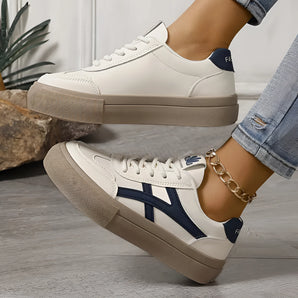 Women's navy fashion sneakers featuring an urban chic design with gold anklet detail, shown worn on a leg.