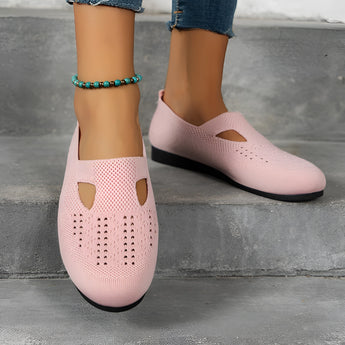 
Women's pink breathable slip-on walking shoes in size 43, featuring a lightweight mesh design, shown being worn on a person's leg.