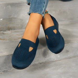 Women's navy blue breathable slip-on shoes featuring a lightweight mesh design, shown worn with denim pants.