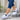 Women's navy blue loafer sneakers with a platform sole and buckle detail, shown in a white color variant.