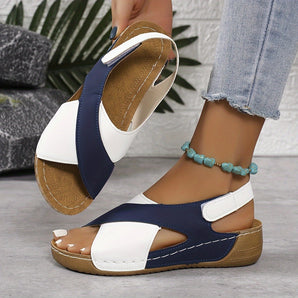 Women's navy and white orthopedic two-tone sandals with ankle straps being worn, highlighting the footwear's design and style.