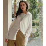 
A fashion model wearing an oversized beige chunky knit wool cardigan with long sleeves, suitable for casual winter wear, in an off-white color and XXL size. The cardigan features a cozy design and is styled against a neutral background, highlighting its texture and fit.