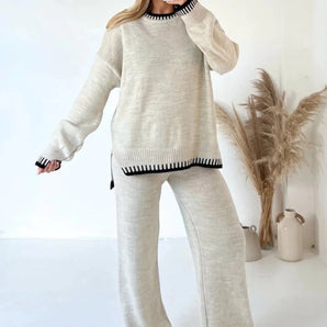 Woman wearing an oversized light gray ribbed knit sweater and baggy trousers, cozy and casual outfit in XL size, paired with casual footwear.