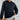
A woman wearing an oversized black pullover hoodie, showcasing its relaxed and stylish design, perfect for comfortable lounging.