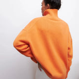 Women's oversized black turtleneck sweater worn by a model, showcasing long sleeves and a relaxed fit, ideal for casual winter wear.
