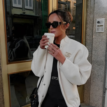 Oversized gray wool blend coat with a chunky knit texture, featuring a wide collar and long sleeves. The coat is styled for a winter fashion look.