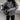 Women's oversized gray wool blend coat featuring a chunky knit design, with a large collar and long sleeves. The coat falls to the knee, providing a warm and stylish option for winter fashion in a muted gray color.