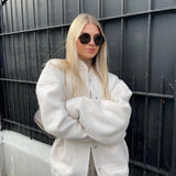 
A woman wearing an oversized gray wool blend coat with a chunky knit design, suitable for winter fashion, showcasing the coat's sleeve and shoulder details.