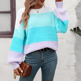 
A woman wearing a cozy, oversized pastel striped knit sweater in shades of aqua and purple, paired with jeans. The sweater features a loose fit and long sleeves, with the stripes creating a casual yet stylish look. The woman has her hair styled casually, and the overall appearance is comfortable and trendy.