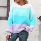 A cozy oversized knit sweater with pastel aqua and purple stripes, featuring long sleeves and a relaxed fit.