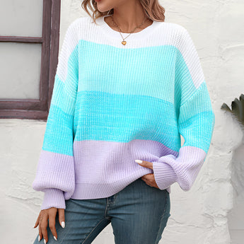 A cozy oversized knit sweater with pastel aqua and purple stripes, featuring long sleeves and a relaxed fit.