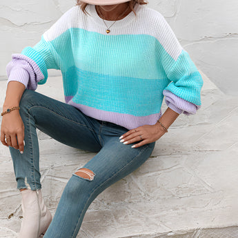 Women's oversized pastel striped knit sweater in aqua and purple tones, featuring long sleeves.