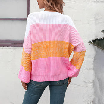 
A cozy women's oversized knit sweater featuring pastel aqua and purple stripes, showcasing a relaxed fit with long sleeves and a round neckline.