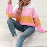 Women's oversized pastel striped knit sweater in aqua and purple, styled as a cozy pullover and paired with jeans.