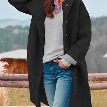 Oversized pink wool winter coat for women featuring chunky buttons, stylish design, and a standing collar, modeled by a person wearing eyewear and denim, highlighting the coat's fashionable appeal and warmth for winter.
