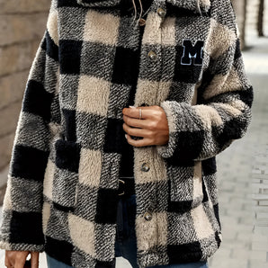 Women's oversized plaid fleece shacket featuring a monogram "M" design, combining black and white tartan patterns with long sleeves, a cozy winter style.