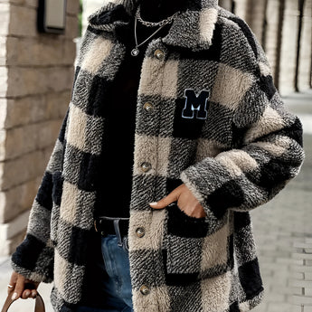 Women's oversized plaid fleece shacket in black and white tartan pattern with the letter "M" monogrammed on the front, featuring long sleeves, a classic collar, and cozy fabric suitable for winter wear.